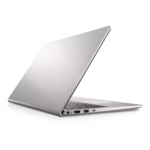 Vista trasera en ángulo de una laptop Dell Inspiron 3520 plateada parcialmente abierta, mostrando el logo de Dell en la tapa y los puertos en el lateral visible: un puerto de carga, un puerto HDMI y puertos USB. Se aprecia parte del teclado.