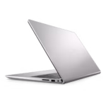 Vista trasera en ángulo opuesto de una laptop Dell Inspiron 3520 plateada parcialmente abierta, mostrando el logo de Dell en la tapa y los puertos en el lateral visible: una ranura para tarjeta SD, un puerto USB y un conector de audio. Se aprecia parte del teclado.
